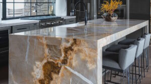 Modern kitchen with marble island and bar stools.