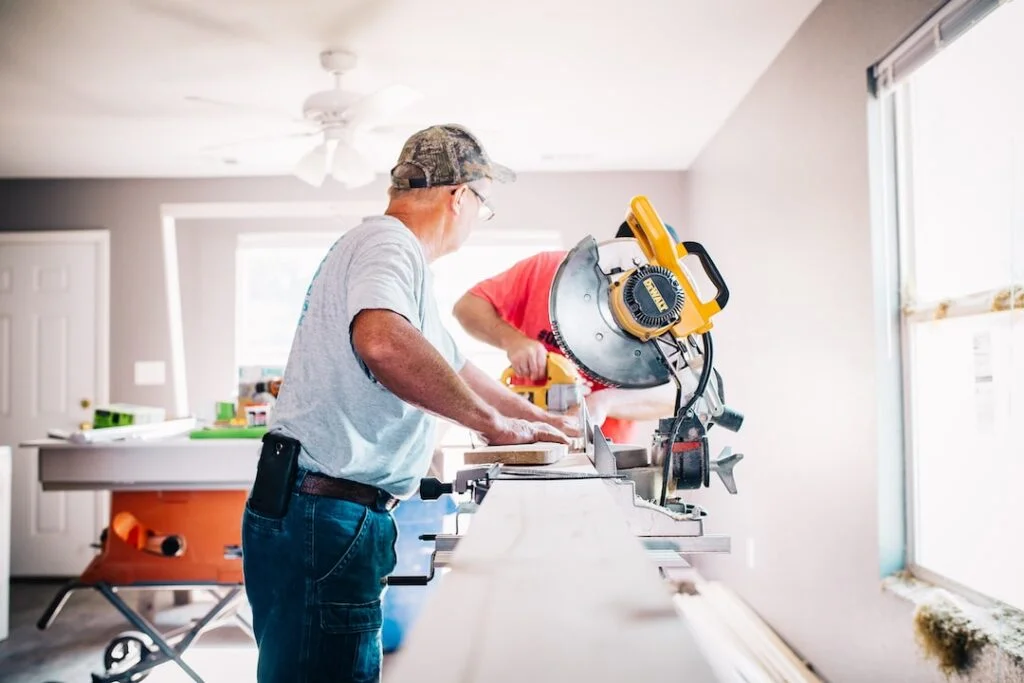 Man using miter saw for home renovation.
