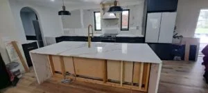 Kitchen under renovation with island and new cabinets.