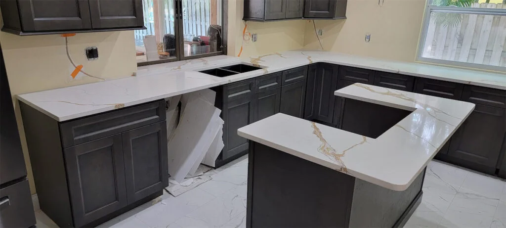 Modern kitchen with dark cabinets being installed.