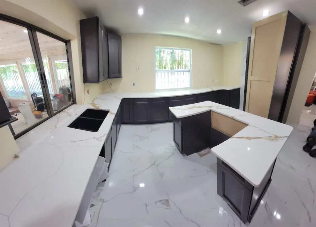 Modern kitchen with white marble countertops.