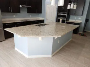 Modern kitchen with large granite island countertop.