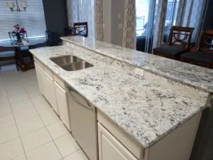 Modern kitchen with granite countertops and island sink.