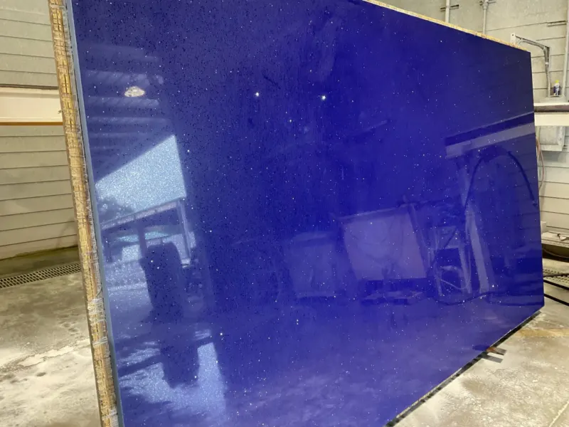 Polished blue granite slab in factory setting.