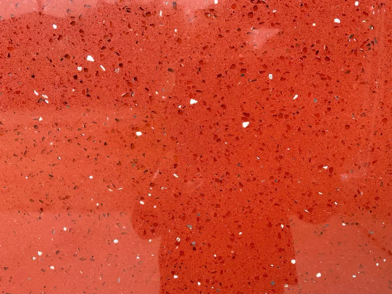 Close-up of red textured surface with speckles.