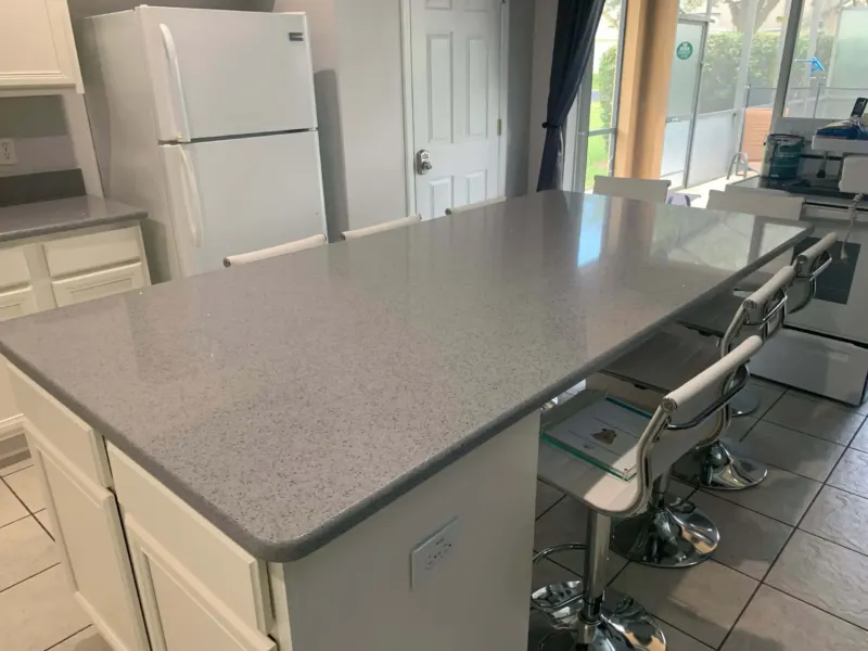 Modern kitchen with granite countertop and bar stools.