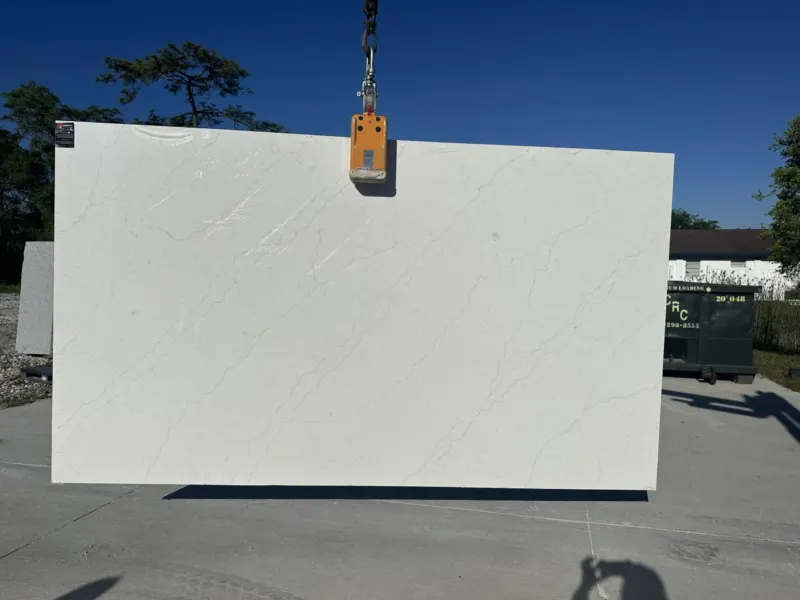 Large white marble slab lifted by machinery.