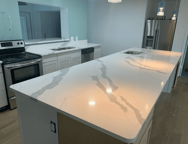Modern kitchen with large marble island countertop.