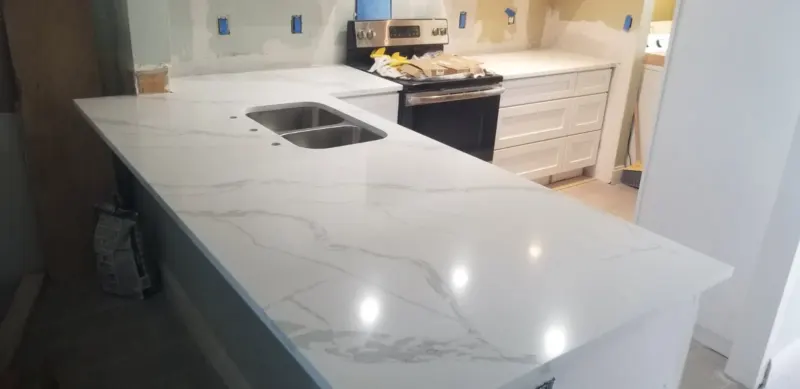 White marble kitchen counter with stainless steel sink.