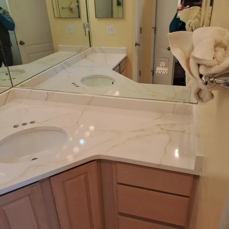 Marble countertop with sink and mirror reflection.