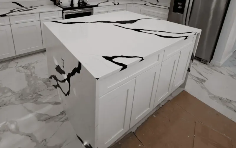Modern kitchen with marble island and counters.