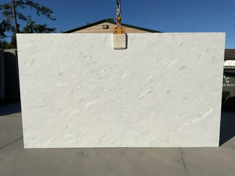 Large white marble slab outdoors under crane.