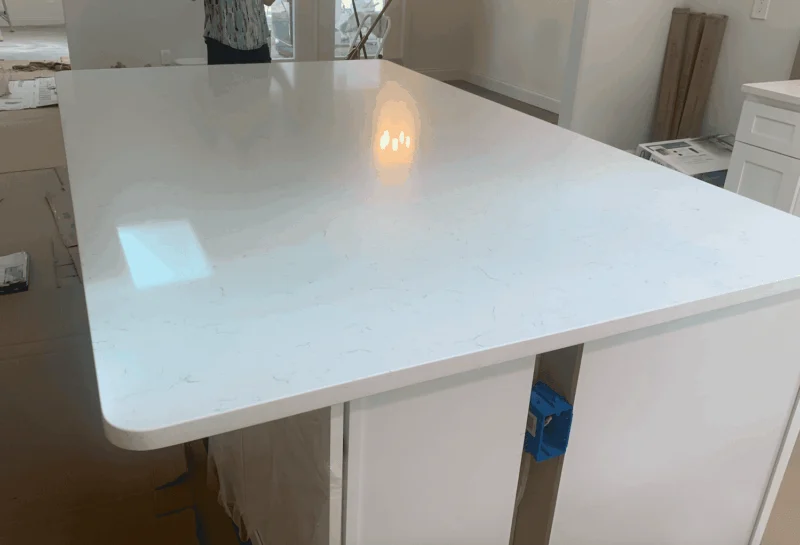 White quartz countertop in unfinished kitchen.