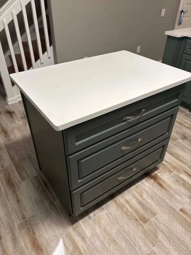 Kitchen island with white countertop and drawers.