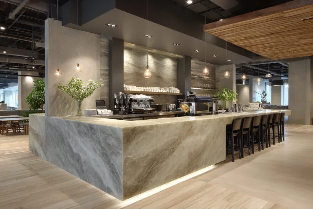 Modern cafe interior with marble counter and seating.