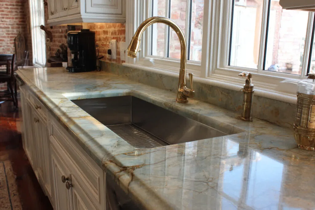 Elegant marble kitchen countertop with gold faucet