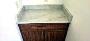 Calacatta Crema Marfil quartz desk with polished veined surface installed in a bright neutral office room
