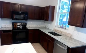 Ornamental White granite kitchen countertop with undermount sink cutout showing an even reveal against light stone