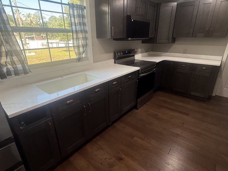 White quartz kitchen countertops with dark cabinets, fabricated and installed by EdStone in Orlando