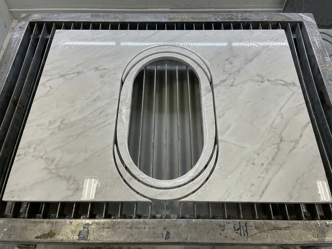 Stone slab with a curved island top cut out leaving unusable crescent shaped offcuts