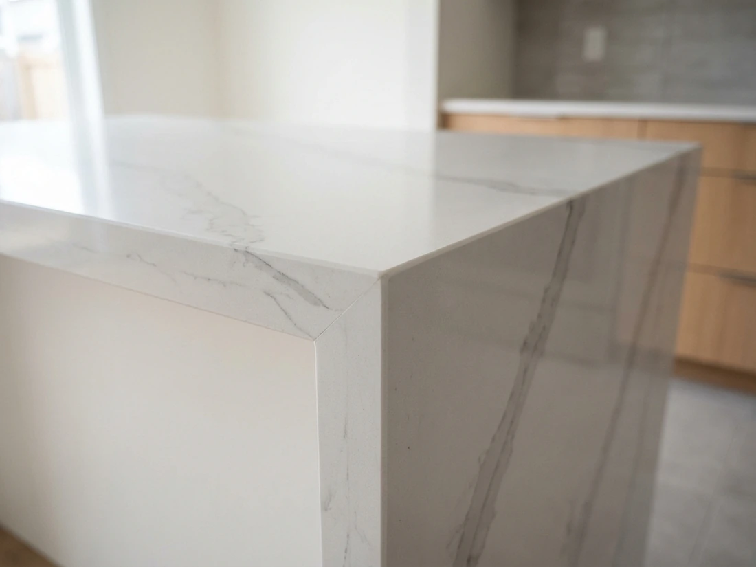 Mitered corner joint on a waterfall island where two cut faces of quartz meet