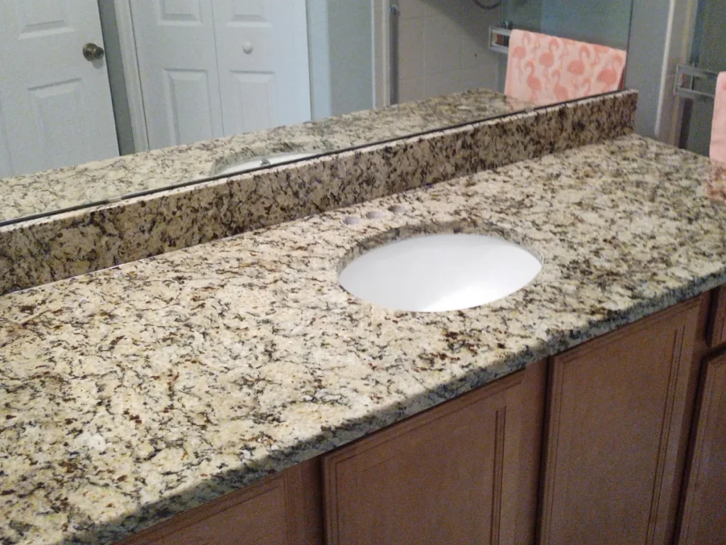 Same bathroom after installing Santa Cecilia granite with a matching backsplash