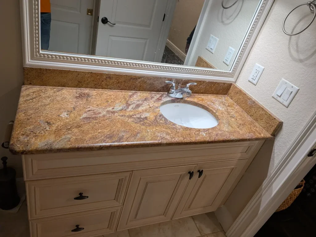 Bathroom before replacement, a dated stone countertop