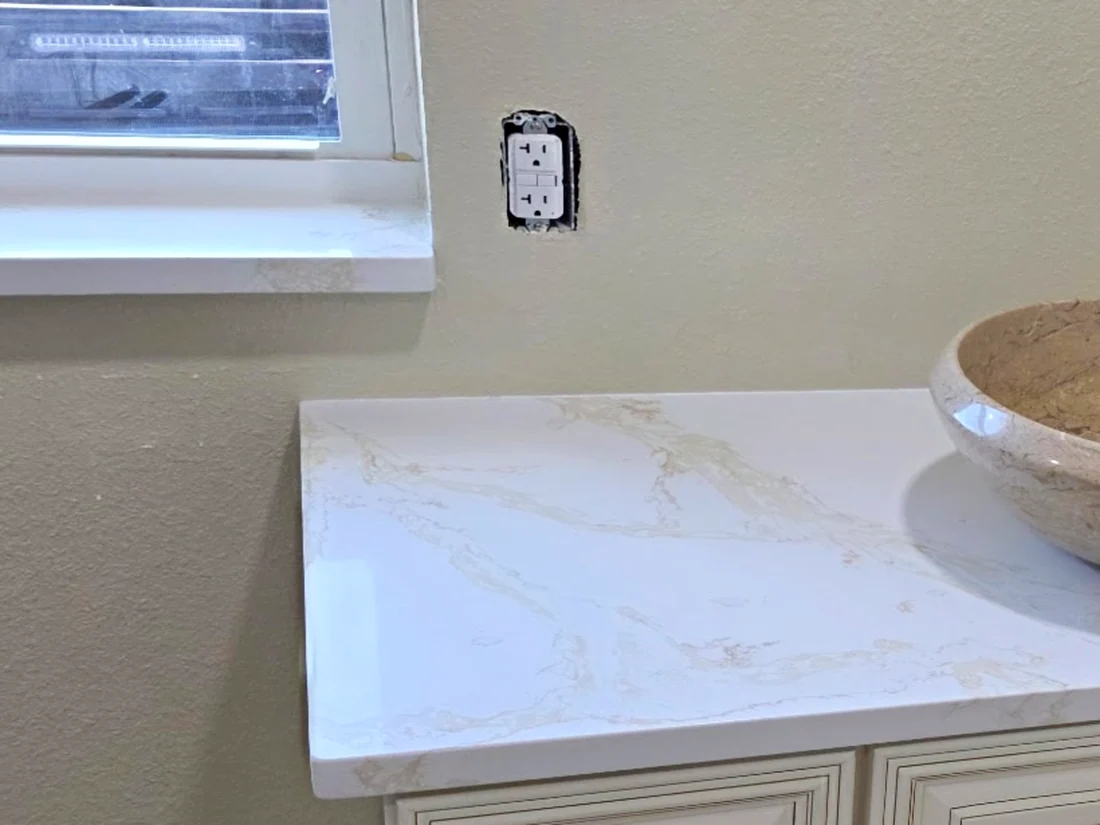 White quartz window sill overhanging a textured wall above a matching quartz vanity top
