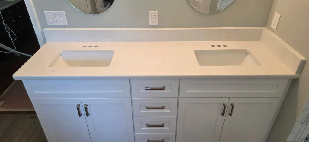 Carrara Gold quartz double-sink bathroom countertop on white cabinets