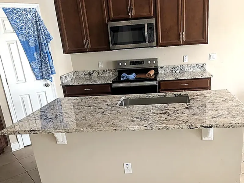 Granite kitchen peninsula beside a cooking area